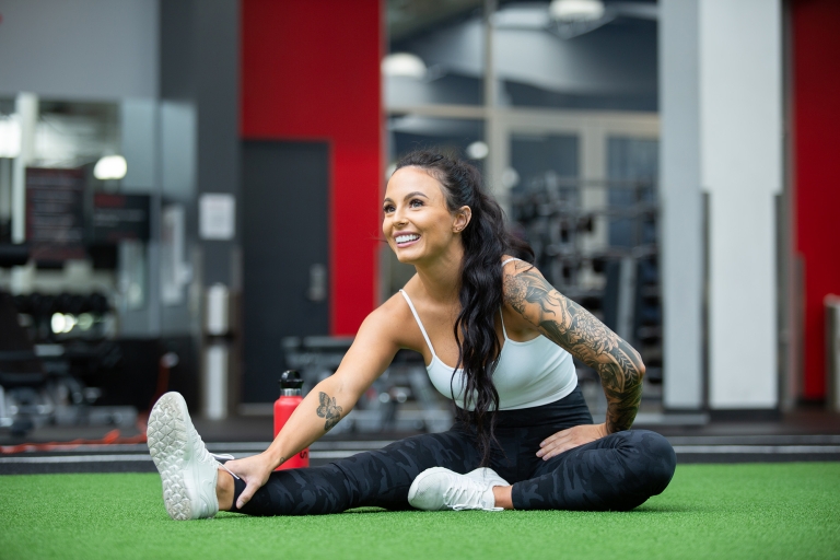 Woman happy stretching on the turf at VASA Fitness