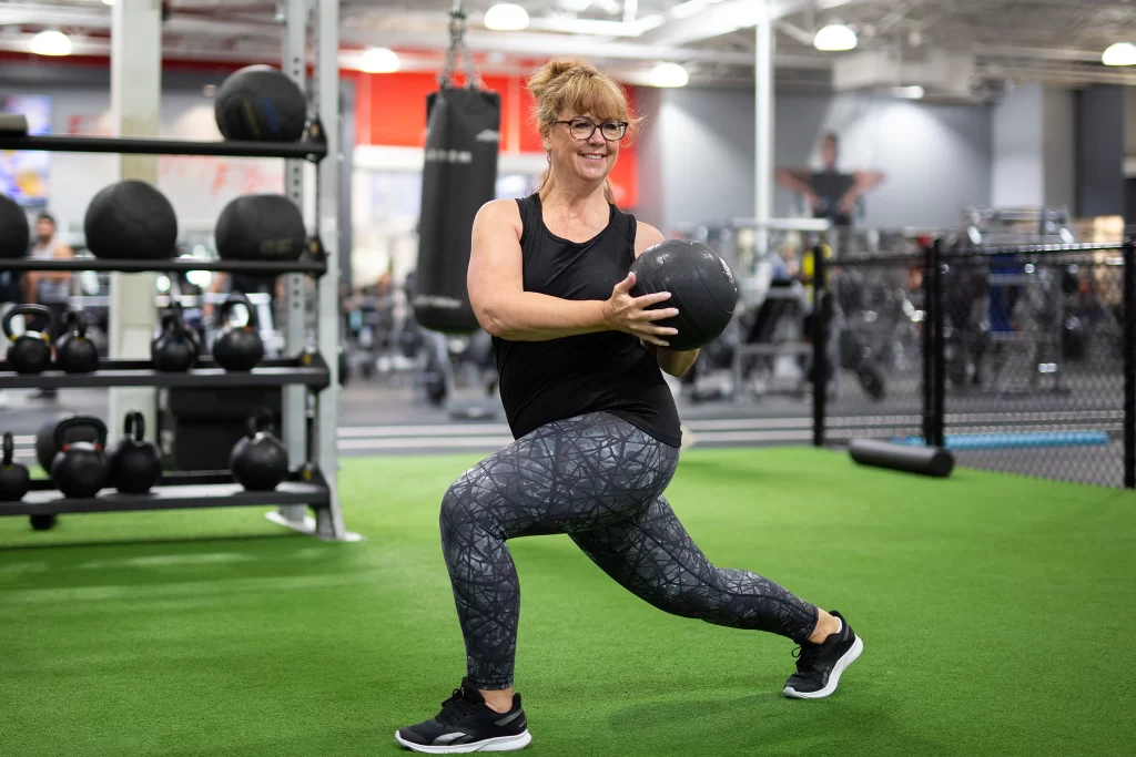 Female athlete doing a medicine ball workout on turf